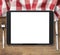 Black tablet pc on wooden table with fork and