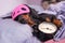 Black and tan dog breed dachshund sleep in bed with sleeping mask and alarm clock. Live with schedule, time to wake up