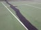 Black tar to repair cracks on green tennis court