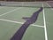 Black tar to repair cracks on green tennis court