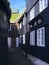 Black-tarred grass-roofed houses with dried fish hanging on hooks and narrow cobblestone street in TÃ³rshavn.