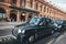 Black taxi stop and waiting for passengers or travelers in front of Kings Cross St Pancras station.