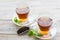 Black tea ceremony - glass full of tea, tea leaves, spices on a wooden boards background