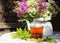 black tea glass cup white kettle table sunlight close-up bouquet flowers