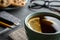 Black tea with lemon slices on a napkin of burlap with notepad pen, a pencil a plate of cookies and glasses