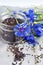 Black tea mix with dried cornflower petals and thyme in glass jar with fresh cornflowers