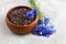 Black tea mix with dried cornflower petals and thyme in wooden bowl. Herbal tea