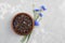 Black tea mix with dried cornflower petals in wooden bowl. Herbal tea.