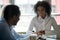 Black team leader having conversation with colleagues during meeting