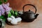 Black teapot, zephyr sweet dessert on silver platter and lilac spring flowers. Tea time background. Food still-life.