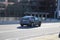 A black Tesla Model Y driving along a street surrounded by buildings in downtown Atlanta