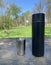 Black Thermos Bottle And Silver Metal Cup On Wooden Table In The Park