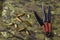 Black Throwing knives and casings on camouflage cloth