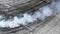 Black tire marks and white smoke on asphalt race track, Road dust cloud from driving car, Combustion fumes of car exhaust pipe,