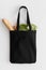 Black tote bag mockup with groceries on a white table