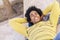 Black tourist with afro hair lying on the ground outdoors.