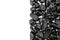 Black tourmaline heap jewel on half light surface texture. Pile mineral pebbles background.