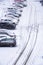 Black traces on the snow-covered asphalt of the parking lot.