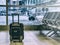 Black traveling luggage in airport terminal and passenger plane is in the background