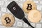 Black Trezor hardware wallet for cryptocurrency with golden bitcoin and ethereum coins