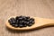 Black Turtle Bean legume. Grains in wooden spoon. Rustic.