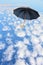 Black umbrella flies in sky over clouds.Mary Poppins Umbrella.