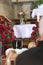 Black urn on the funeral day in church; surrounded with daisies and roses