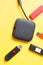 Black USB HUB with usb stick flash drives on yellow background. Top view