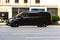 Black van Mercedes-Benz W447 Viano in the city street in motion. Premium minivan car rushes on highway, side view