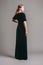 Black velvet trumpet dress. Evening floor length gown with deep v neck line and short sleeves. Beautiful young brunette lady