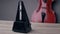 A black vintage metronome beats the rhythm while standing on the table, a cello is lying behind, a close-up shot