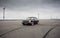 black Volga sedan parked on big empty asphalt field