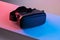 Black VR glasses mask on neon color background. Virtual reality headset