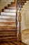 The black walnut newel post at the the bottom of a staircase.