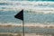 Black warning flag marking the limit of the safe swimming area a