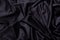 black wavy fabric background close-up.
