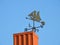 Black weather vane on home roof, Lithuania