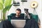 black and white amstaff dog observes his owner working on laptop home background medium full shot remote job concept