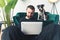 black and white amstaff dog watches young Caucasian man working on laptop home background medium full shot remote job