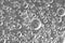 Black-and-white background with big and small grey bubbles inside a gray liquid.