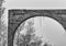 Black and white background image of brick arch and trees