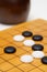 Black and white baduk stones on wood board