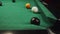 Black and white billiard ball number eight swiftly rolling directly into the corner pocket by hit of white ball close up