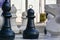 Black and white chess pieces on board in large scale outdoor chessboard