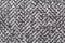 Black and white colored woven synthetic material rough structure macro, extreme closeup, abstract grey textile surface, top view