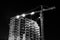 Black and white Construction building site with tower cranes building under construction lighted with projectors at