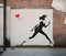 Black and white drawing of girl on wall running away from red heart, old brick plastered wall, street art