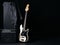 Black and white electric bass guitar with amplifier, jack cable