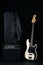 Black and white electric bass guitar with amplifier, jack cable, hard case