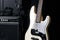 Black and white electric bass guitar with amplifier, jack cable, hard case